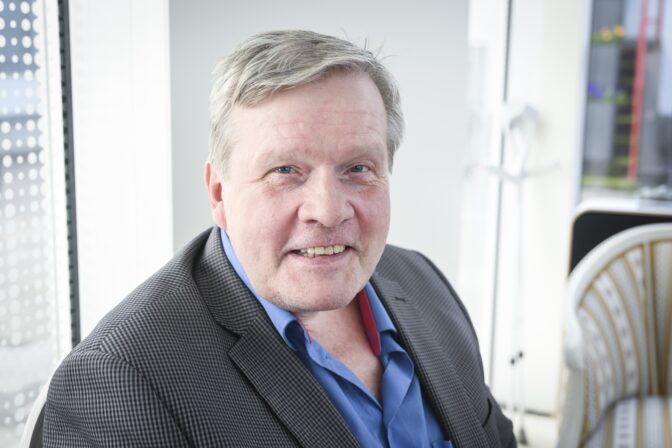 Kuvassa Lauri Late Karhuvaara joka muistetaan Huomenta Suomen pitkäaikaisena juontajana katsoo kameraan ja nauraa.